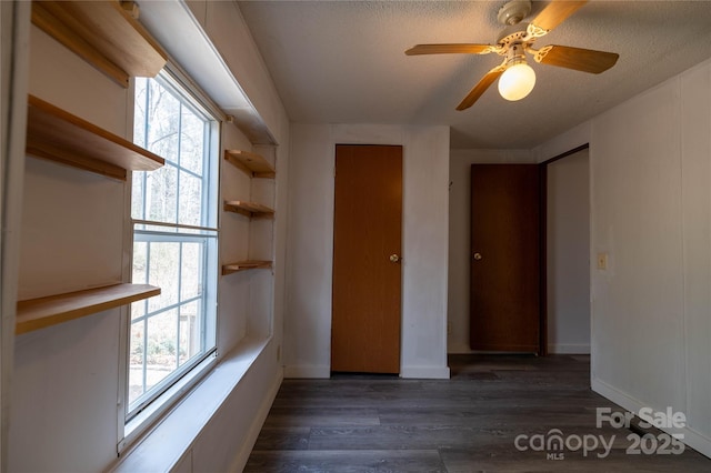 spare room featuring a healthy amount of sunlight, baseboards, and wood finished floors