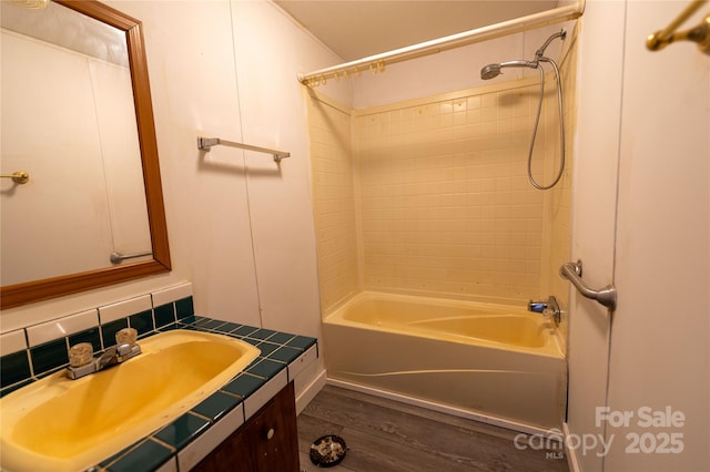 bathroom featuring tub / shower combination, wood finished floors, and vanity