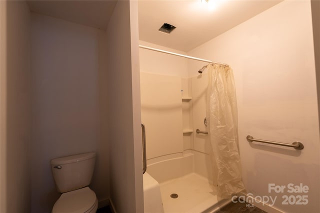 full bathroom featuring a stall shower and toilet