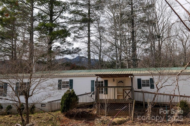 view of front of home featuring metal roof and a wooden deck