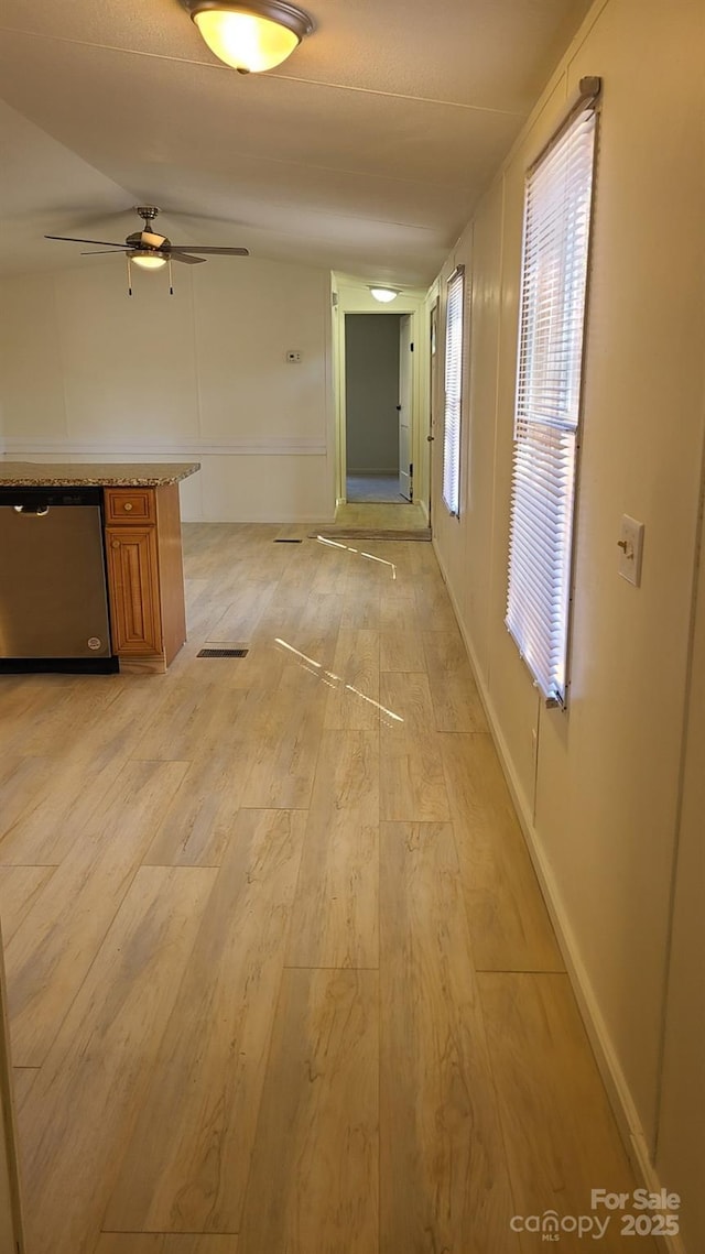 hall with light wood-style floors and baseboards