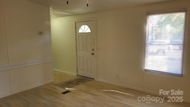 entrance foyer featuring plenty of natural light, visible vents, and wood finished floors