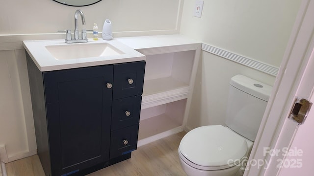 bathroom with vanity, toilet, and wood finished floors