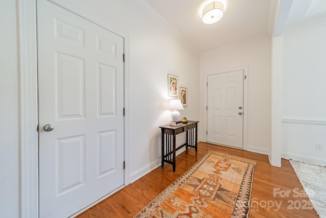 foyer featuring ornamental molding, baseboards, and wood finished floors