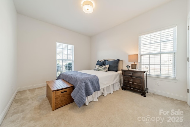 bedroom featuring light carpet, baseboards, and multiple windows