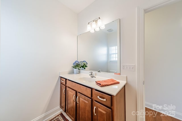 bathroom featuring vanity, toilet, and baseboards