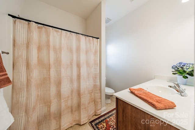 bathroom featuring toilet, tile patterned flooring, and vanity