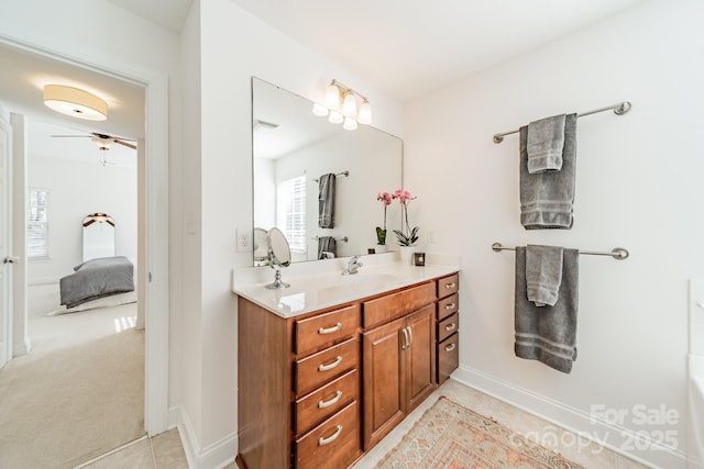 ensuite bathroom featuring tile patterned flooring, vanity, baseboards, and ensuite bathroom