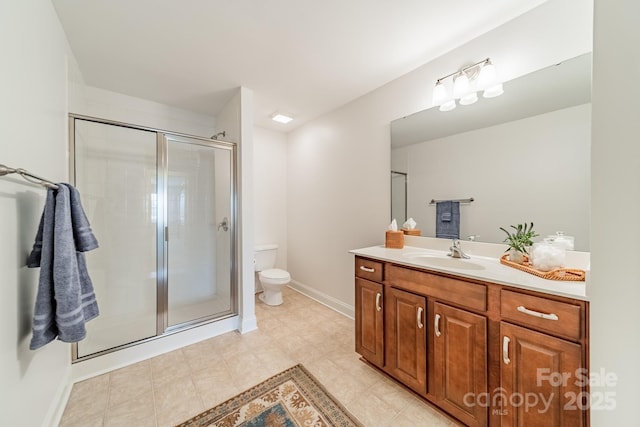 full bathroom featuring a stall shower, baseboards, vanity, and toilet