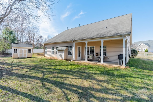 back of property featuring an outbuilding, a patio, a lawn, and a shed