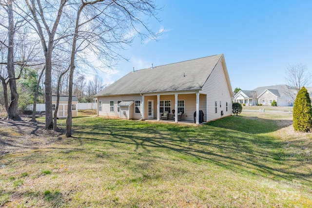 rear view of house featuring a storage shed, a patio area, a lawn, and an outdoor structure