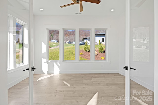 unfurnished sunroom featuring a ceiling fan, french doors, and visible vents