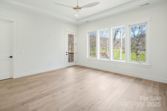 unfurnished room with light wood-style floors, baseboards, and visible vents