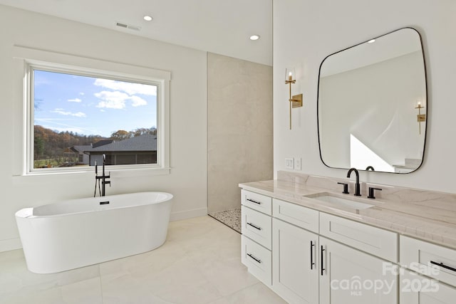 full bathroom featuring a walk in shower, a freestanding tub, recessed lighting, vanity, and visible vents