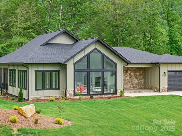 90 Bridgeway Dr Unit 25, Candler, NC 28715 - view of front of home with a shingled roof, an attached garage, board and batten siding, and a front lawn