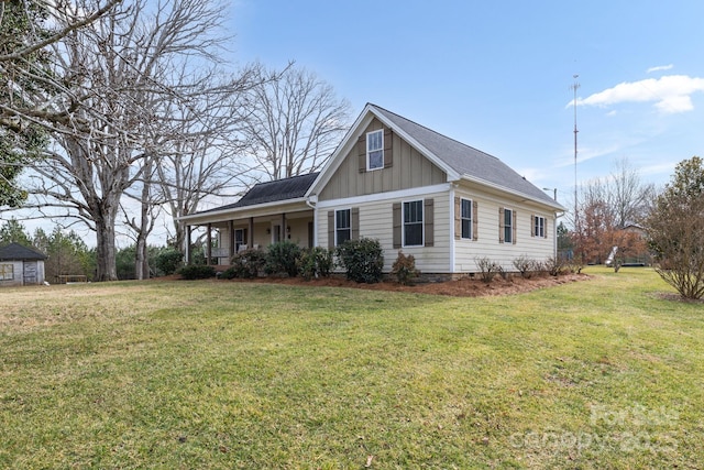 view of front facade with board and batten siding, a porch, and a front lawn