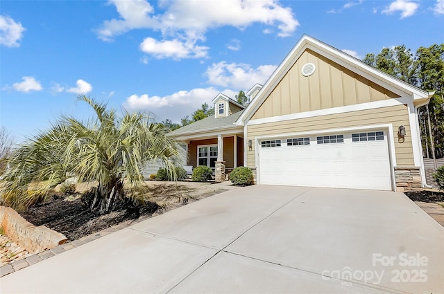 view of front of home featuring a garage, stone siding, board and batten siding, and driveway