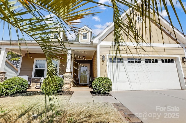 view of front of home with a garage, a porch, and concrete driveway