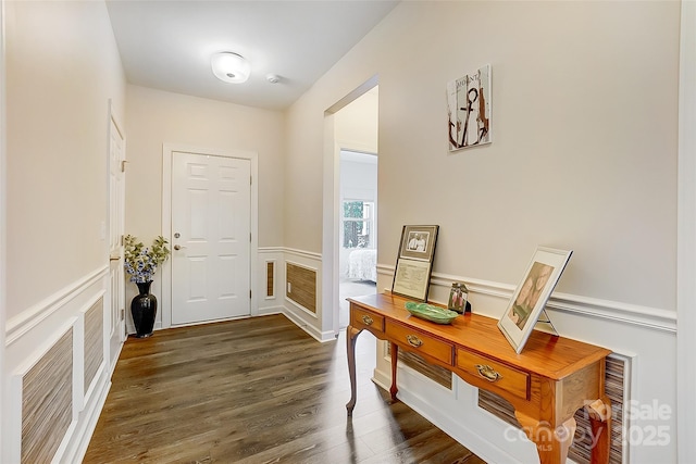 entryway featuring dark wood-style floors and wainscoting