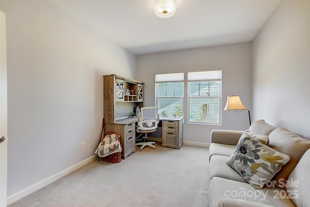 office space featuring light carpet and baseboards