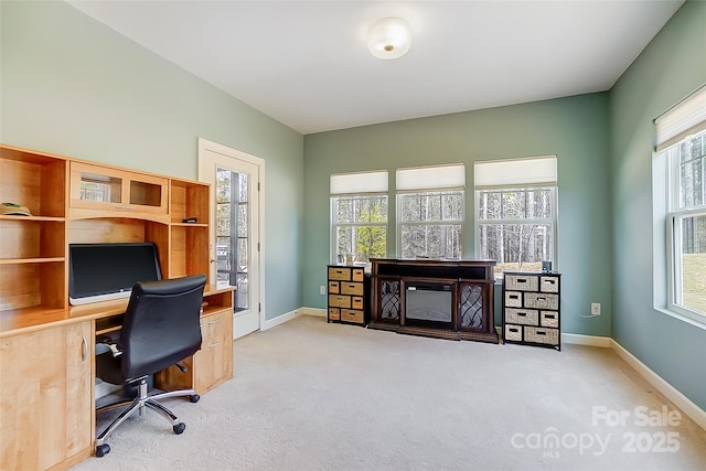 home office with baseboards and light colored carpet