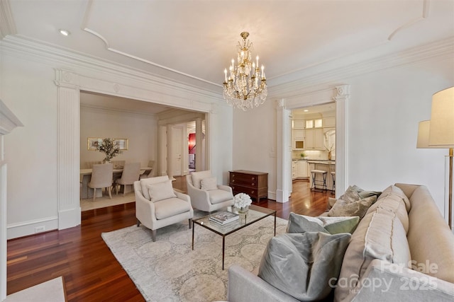 living room featuring dark wood-style floors, a notable chandelier, ornamental molding, and baseboards