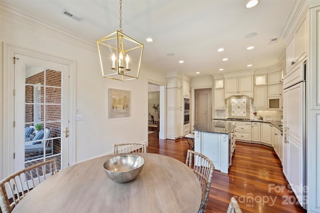 dining room featuring visible vents, dark wood finished floors, crown molding, a notable chandelier, and recessed lighting