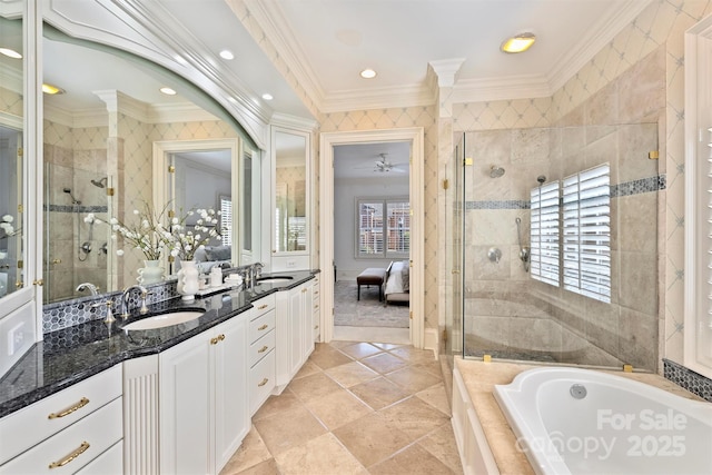 ensuite bathroom featuring double vanity, a shower stall, ornamental molding, and a sink