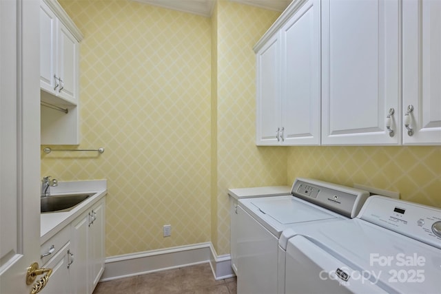 laundry area with cabinet space, washer and clothes dryer, dark tile patterned flooring, ornamental molding, and a sink