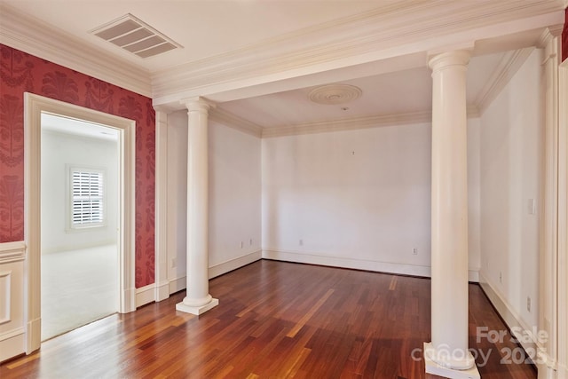 empty room featuring ornate columns, visible vents, dark wood finished floors, and ornamental molding