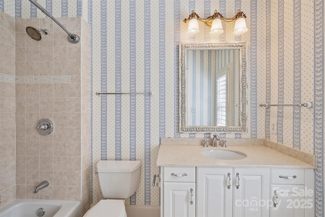 bathroom featuring shower / washtub combination, vanity, toilet, and wallpapered walls