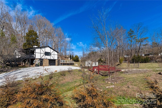 view of yard featuring driveway, a garage, and a deck