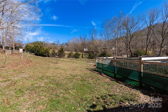 view of yard featuring a rural view and fence