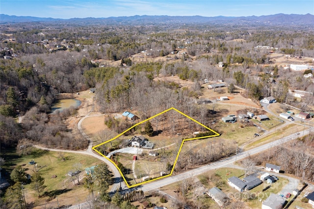 birds eye view of property featuring a mountain view and a view of trees