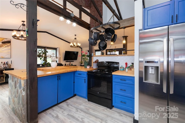 kitchen featuring vaulted ceiling with beams, black range with electric cooktop, wooden counters, blue cabinetry, and stainless steel fridge