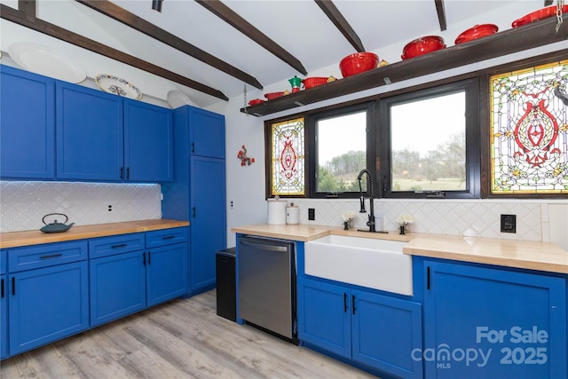 kitchen featuring butcher block counters, a sink, dishwasher, and blue cabinetry