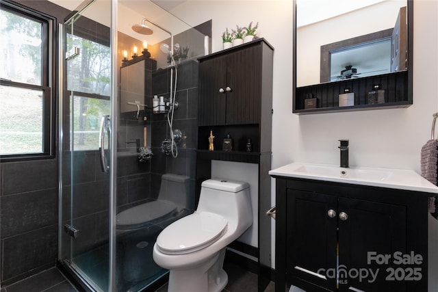 full bathroom featuring toilet, a shower stall, and vanity