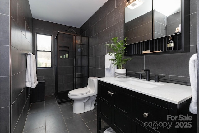 full bath with tile patterned flooring, a shower stall, tile walls, and vanity