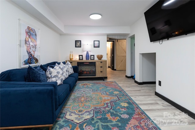 living area featuring light wood finished floors and baseboards