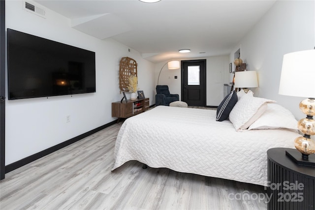 bedroom featuring light wood-style flooring, visible vents, and baseboards