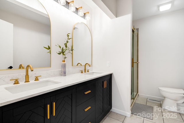bathroom with tile patterned flooring, a sink, a stall shower, and toilet