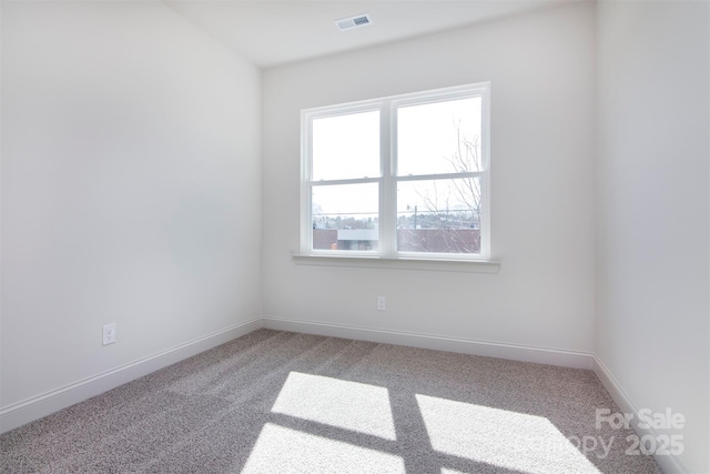 empty room featuring carpet floors, baseboards, and visible vents