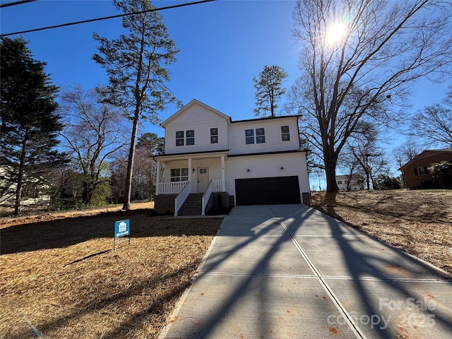 traditional-style home featuring driveway, a garage, and a porch