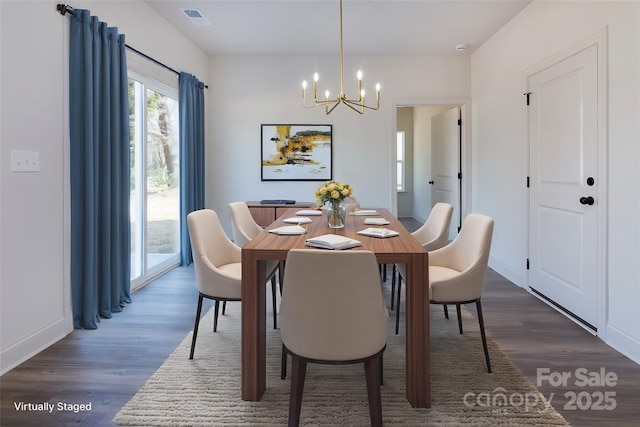 dining room featuring visible vents, a chandelier, and wood finished floors