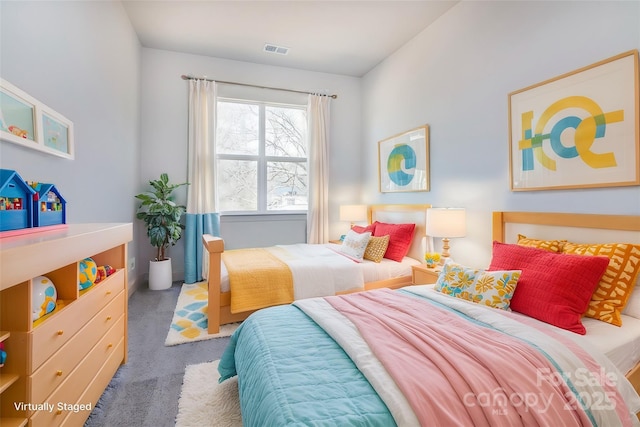 carpeted bedroom featuring visible vents