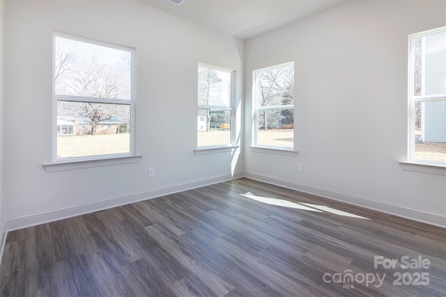 empty room with dark wood-style floors and baseboards