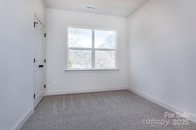 carpeted spare room with visible vents and baseboards