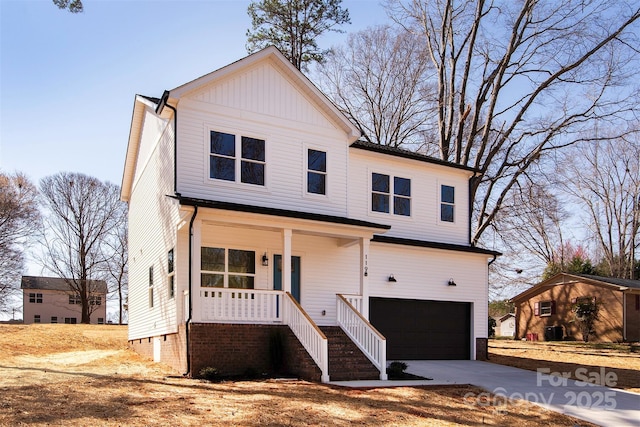 traditional-style house with a porch, a garage, and driveway