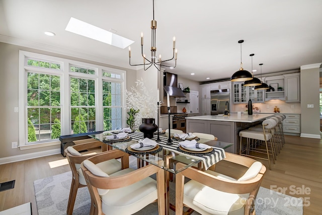 dining room featuring light wood-type flooring, baseboards, crown molding, and recessed lighting