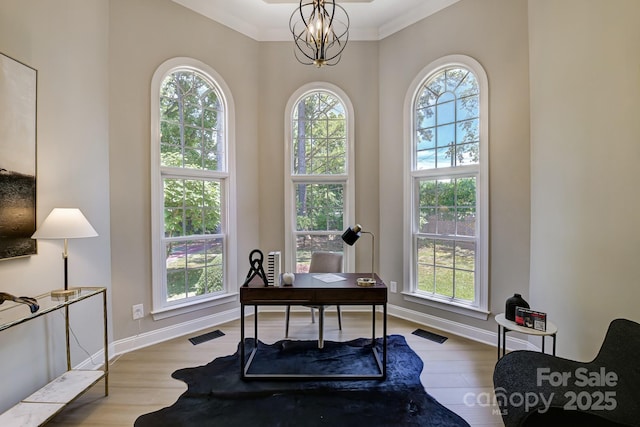 home office featuring a wealth of natural light, visible vents, and wood finished floors